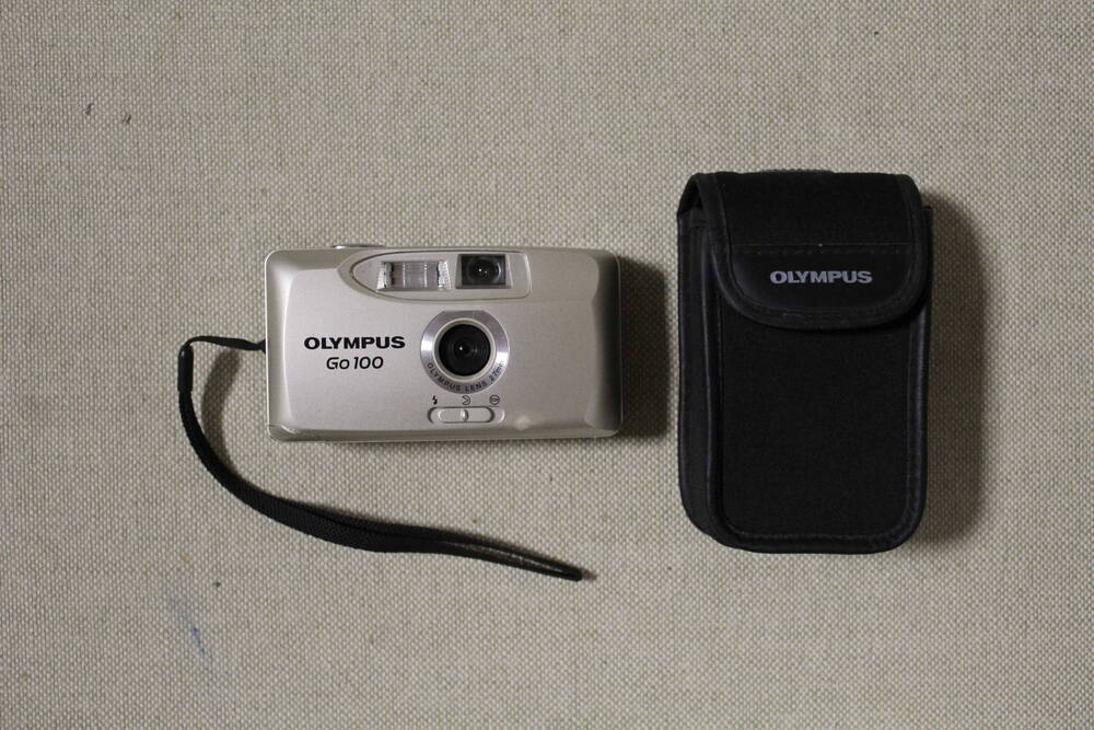 Фотоаппарат пленочный, автоматический Olympus GO 100, в просторечии мыльница, в комплекте с ремешком на руку и тканевым чехлом.