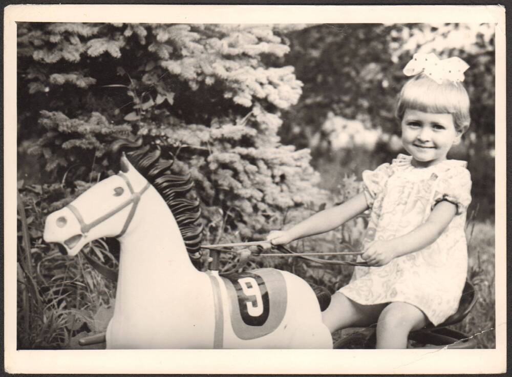 Фото. Девочка (Могилина Таня) на игрушечной лошадке в детском парке.