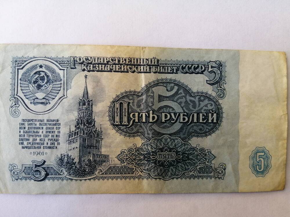 Знак денежный бумажный 5 рублей 1961 г. Лицевая сторона государственный герб и изображение Спасской башки Кремля, на обороте - номинал и номер серии.