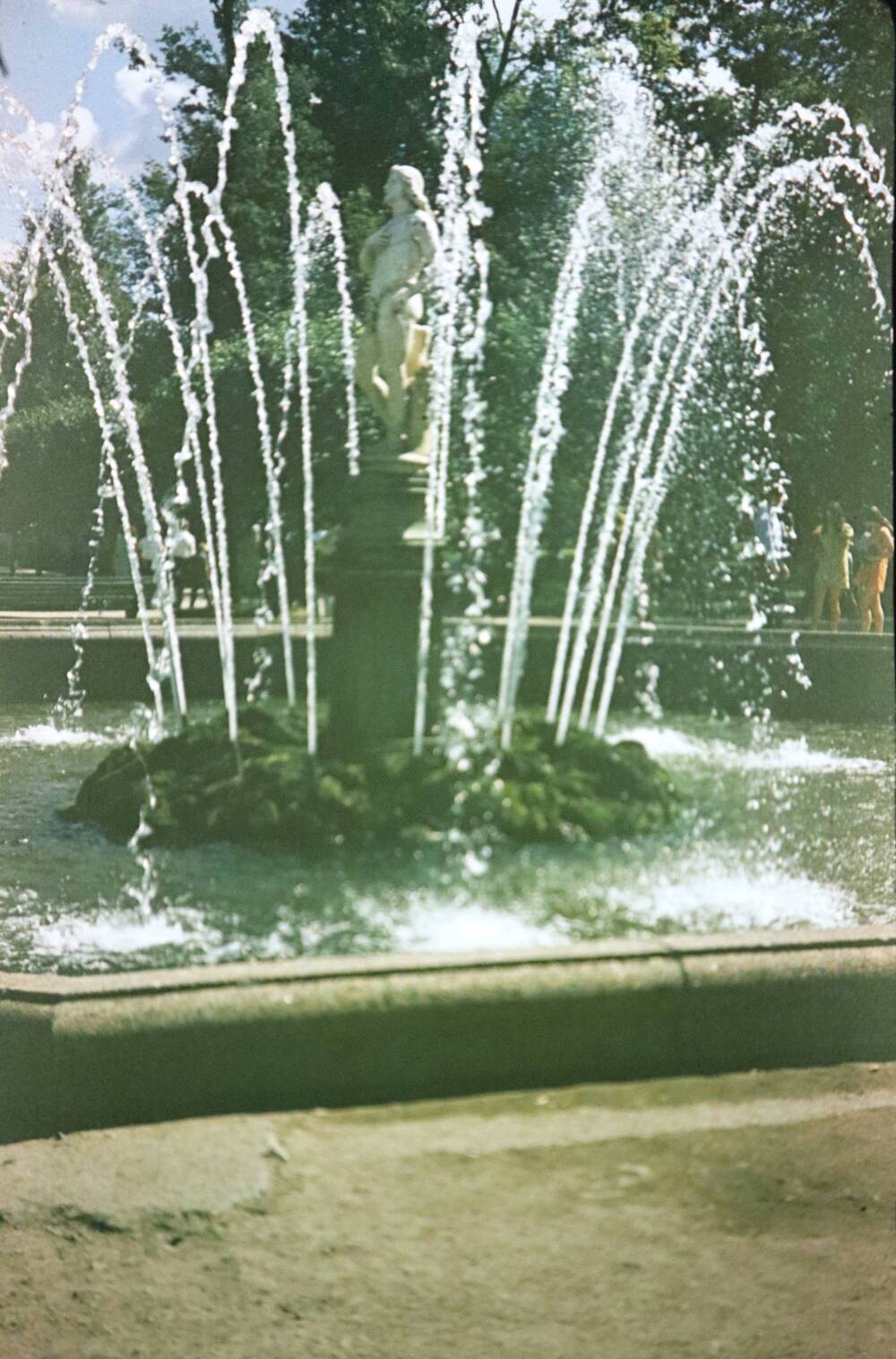 Слайд пластмассовый, на котором изображен летний фонтан со скульптурой человека в полный рост, стоящего на постаменте.