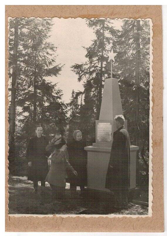 Фотография. Давыдов А.А. стоит на коленях у памятника, где похоронен пулеметный расчет (Бурляков Иван, Мальцев Иван, Ушаков К.) в 1918 году. Рядом родственники погибших.