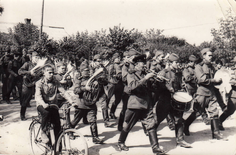 Фотография. Колонна, возглавляемая духовым оркестром завода Дубитель, возвращается из военизированных лагерей.