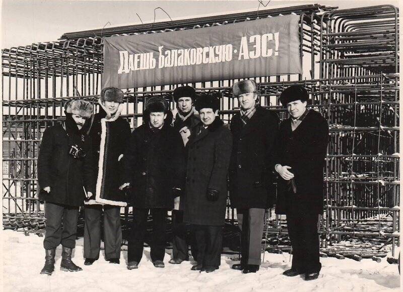 Фотография. Группа мужчин на фоне плаката «Даешь Балаковскую АЭС»