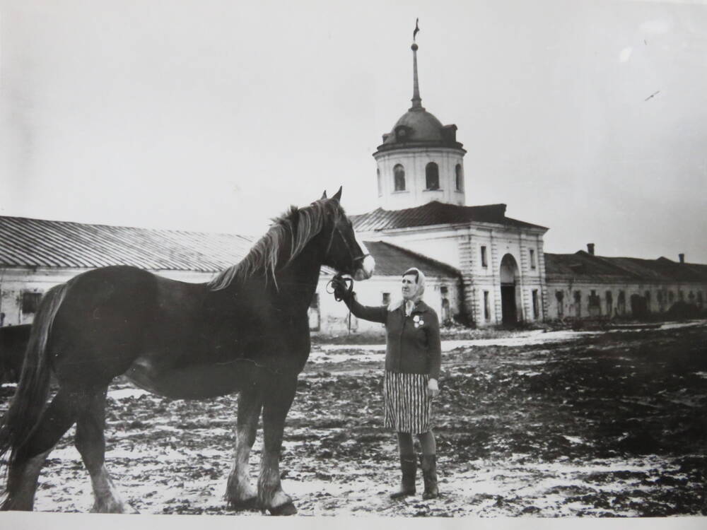 Фотография Знатный конюх Рыбакова Э.Э. у здания госконюшни