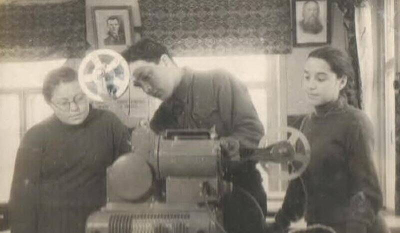 Фотография с изображением учеников Иж-Бобьинской школы, которые рассматривают киноаппарат.