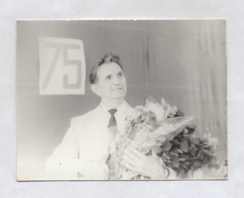 Фотография черно-белая. Изображен В.А. Нашивочников с букетом цветов в руках.