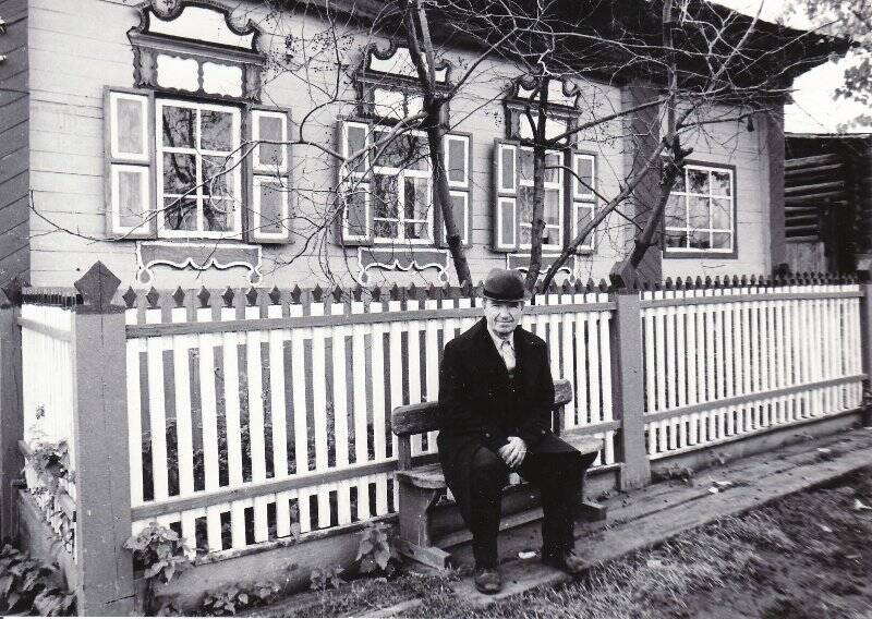 Фотография черно-белая. Черемных Иван Михайлович - участник Великой Отечественной войны, на скамейке у ограды своего дома