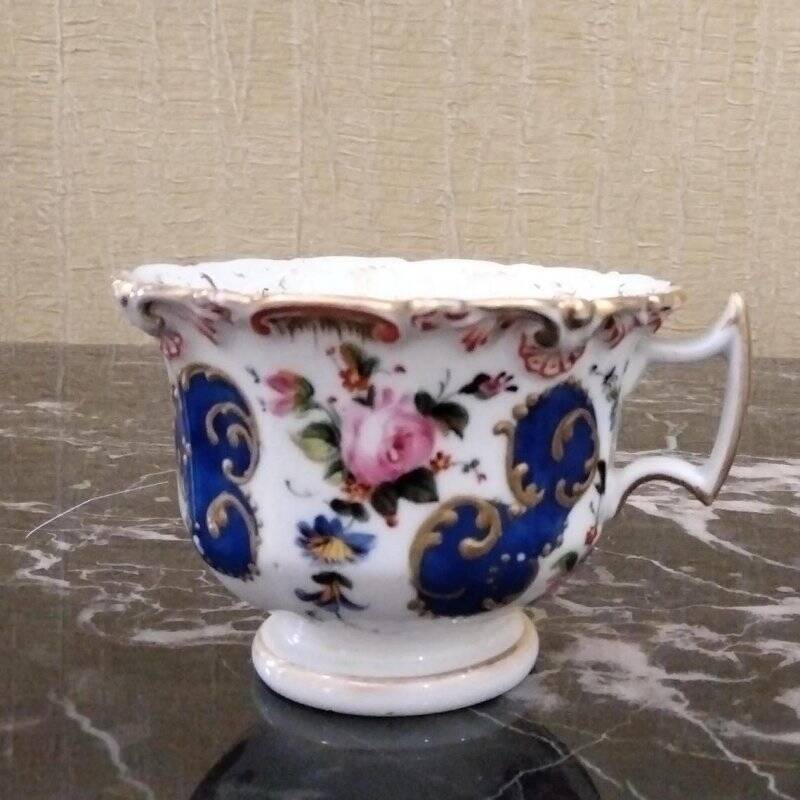Чашка чайная с росписью в виде золоченых рокайлей и цветочных мотивов.