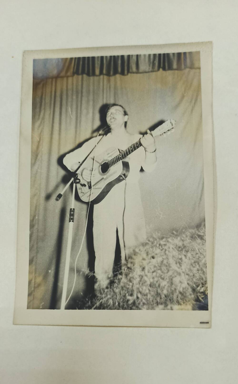 Фотография черно - белая. Изображен мужчина с гитарой.