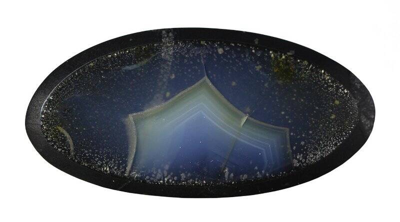 Вставка из дымчатого голубоватого агата на черной подложке с мелкими песчинками пирита. Из коллекции цветных камней Магаданской области.