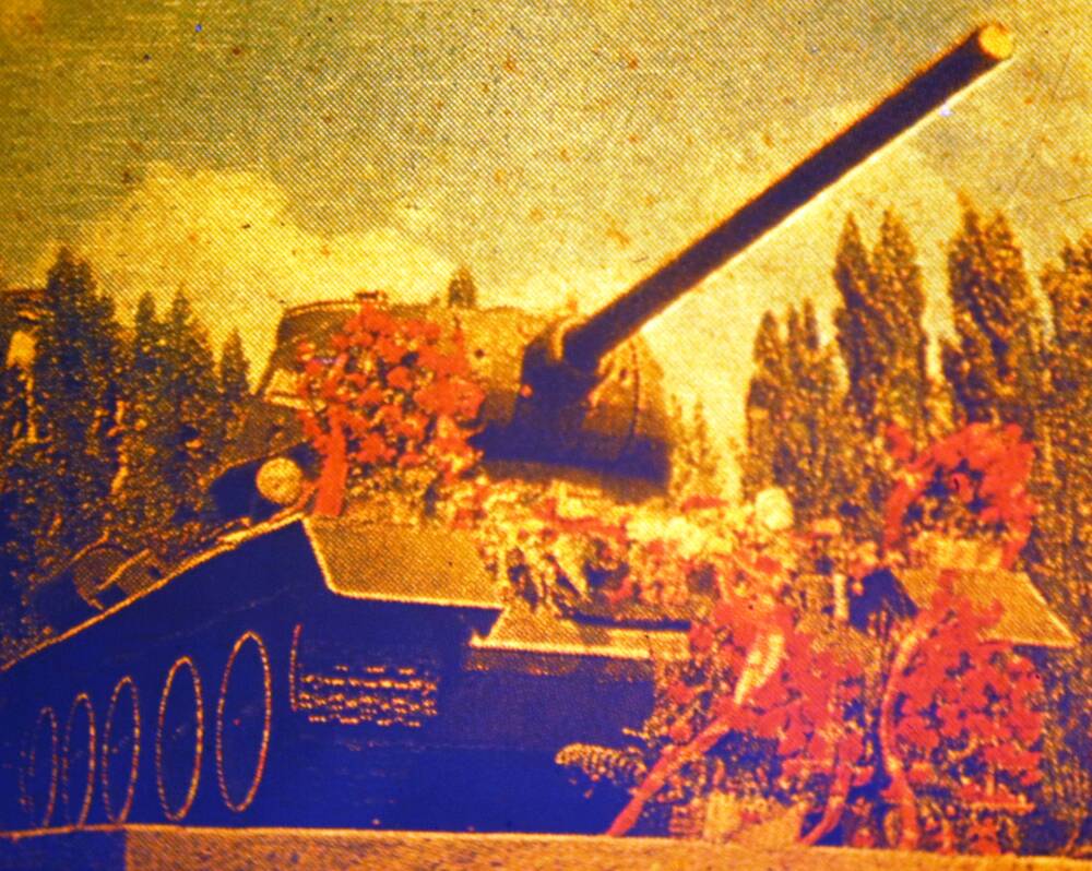 Слайд пластмассовый, где изображен танк т-34, на корпусе которого лежат цветы и венки.