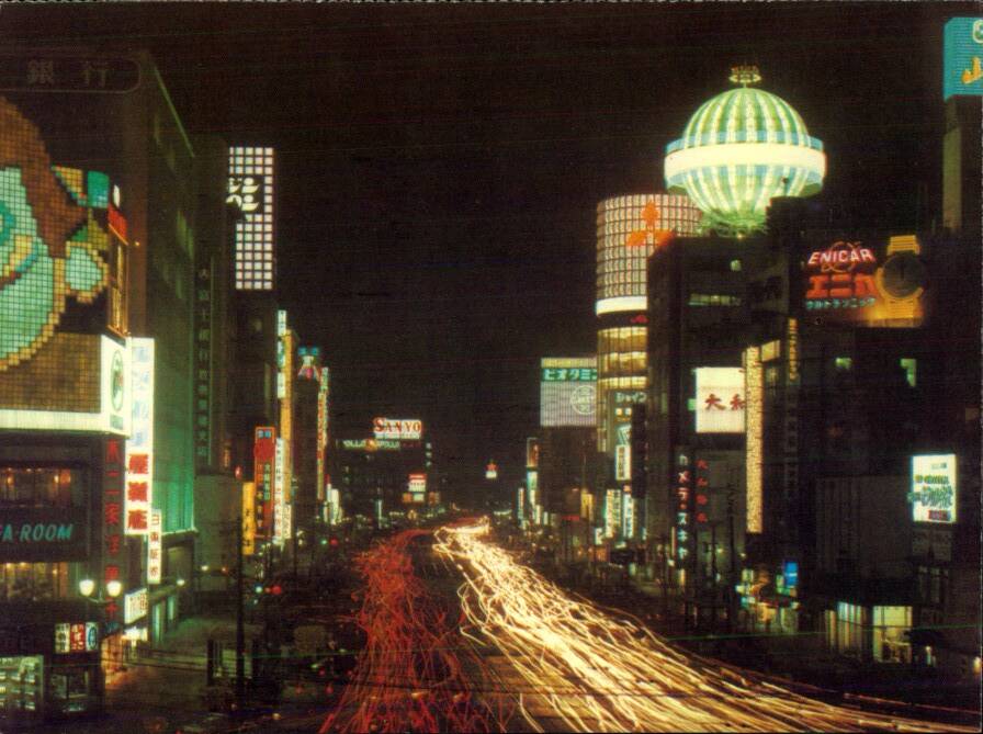 Вечерний вид улицы Гинза в Токио, сверкающей неоновыми рекламами.
