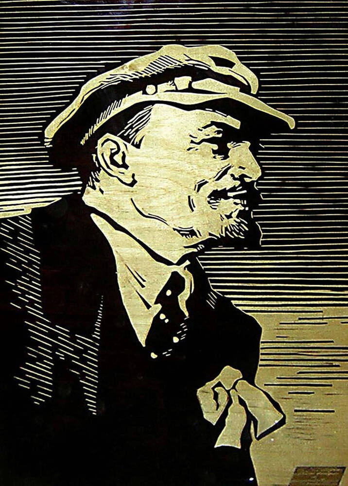 Гравюра по дереву В.И.Ленин. Цвета - бледно-желтый и черный, портрет покрыт лаком. Ленин изображен в черном пиджаке, в кепке, с бантом на груди (в профиль).