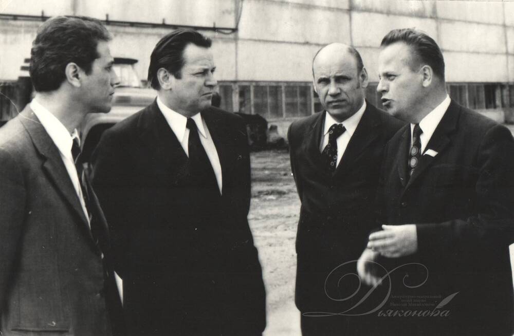 Фотография черно-белая. Балин Н.Н. (второй справа) с делегацией из Коми областного комитета партии на фоне цеха Сыктывкарского лесопромышленного комплекса
