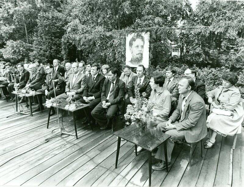 Фотография черно-белая. На трибуне гости и участники праздника поэзии.
