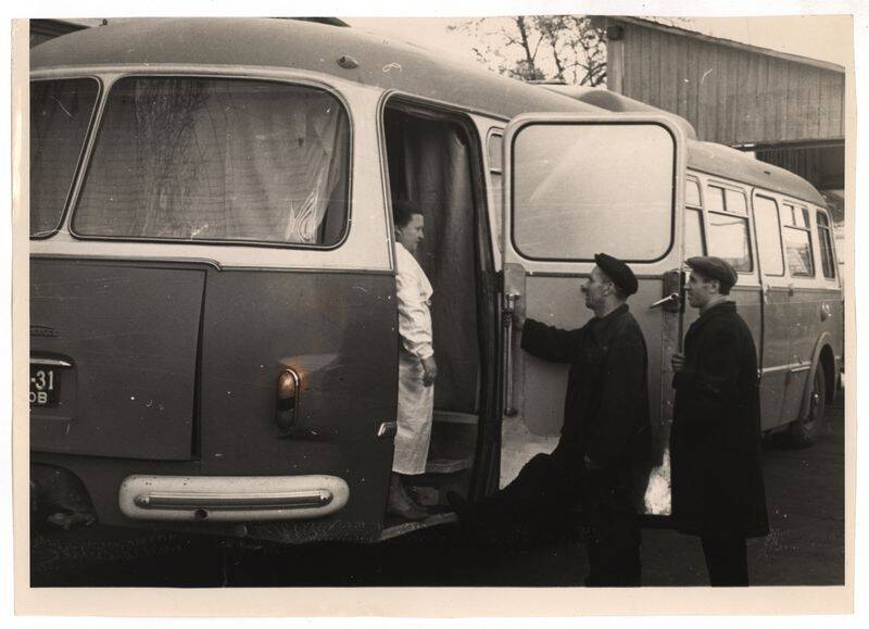 Фото. Автобус с рентгеновской установкой со стоящими рядом людьми.