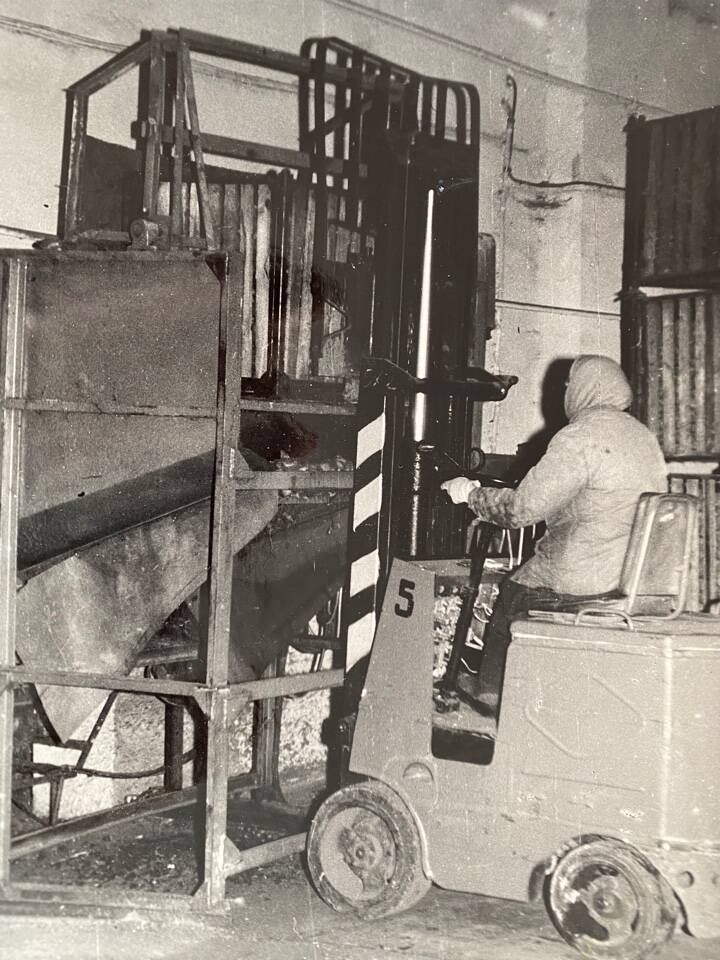 Фото чёрно-белое из альбома Механизация трудоёмких процессов в ОРСе в 1974 году. Механизация загрузки картофеля с помощью транспортера ТЗК и электропогрузчика при контейнерном методе хранения.