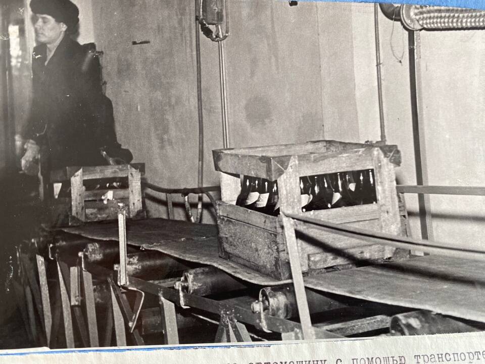 Фото чёрно-белое из альбома Механизация трудоёмких процессов в ОРСе в 1974 году. Погрузка готовой продукции на автомашину с помощью транспортера.