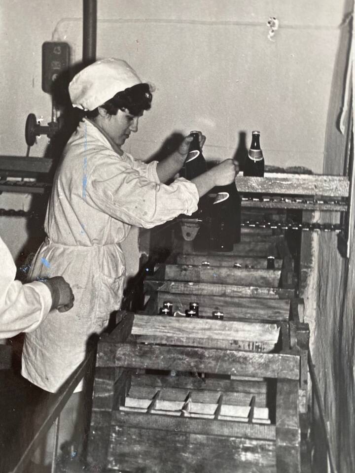Фото чёрно-белое из альбома Механизация трудоёмких процессов в ОРСе в 1974 году. Затаривание готовой продукции в цехе безалкогольных напитков.