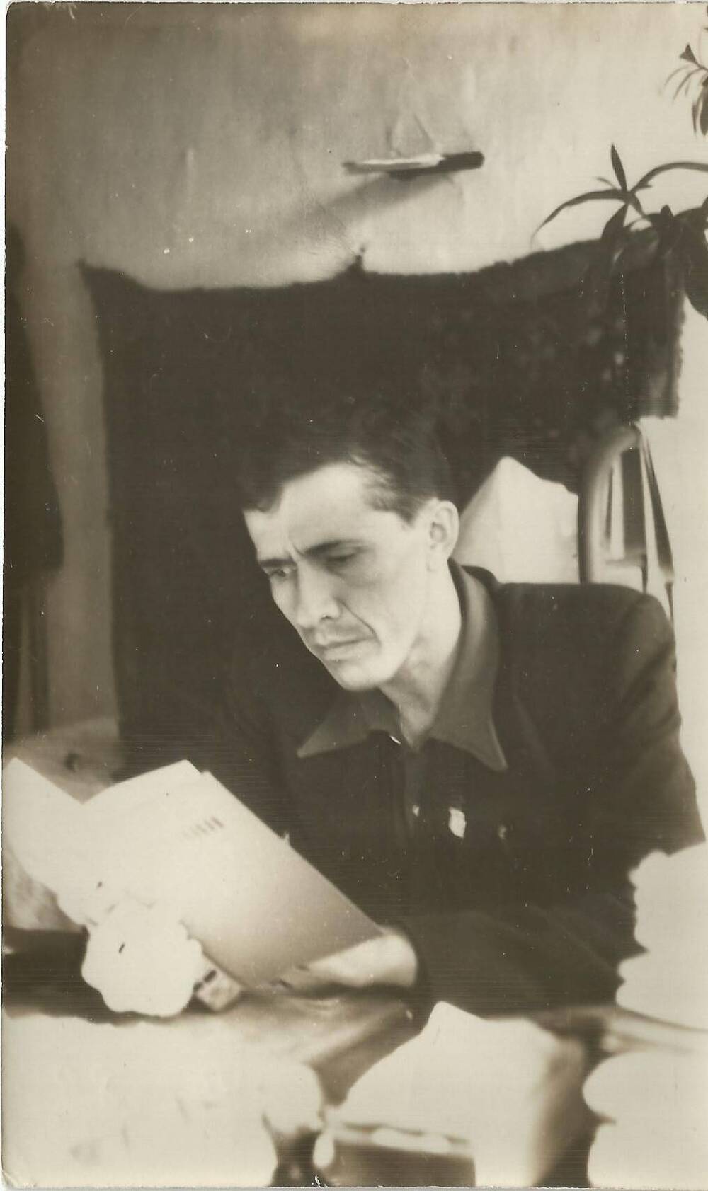 Фотография Д.А. Ильментьев на рабочем месте, с листами бумаги в руках