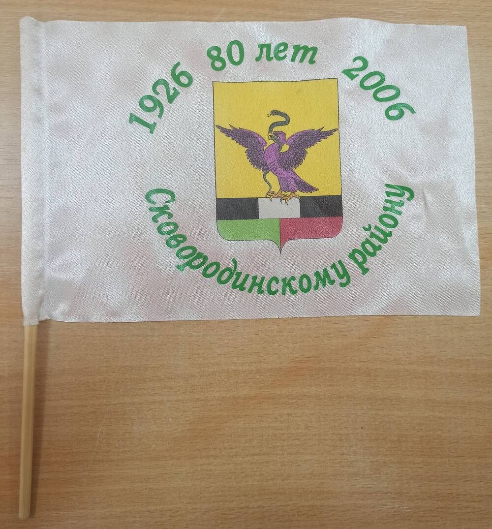 Флажок Сковородинскому району 80 лет 1926-2006 гг. из ткани белого цвета, посреди герб района.