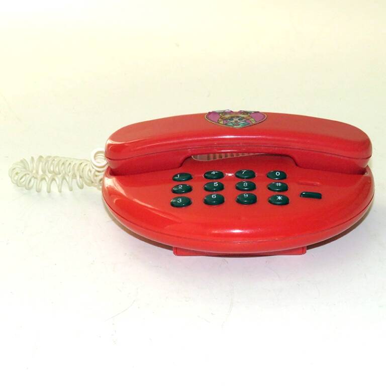 Игрушка. Телефонный аппарат кнопочный. Красного цвета с черными кнопками. На трубке наклейка в форме сердечка. На дне ячейка для 2-х батареек АА. Китай, 1990-е г.