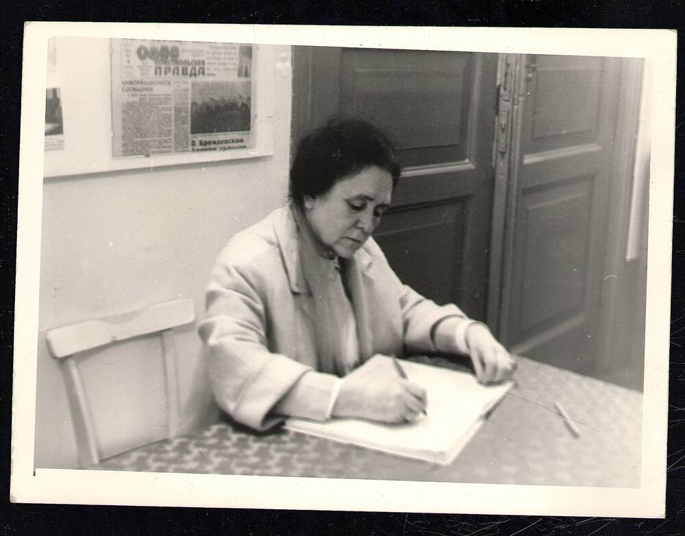 Фотография. Н.А. Мельникова делает запись в книге отзывов Сарапульского краеведческого музея, 1967 г.