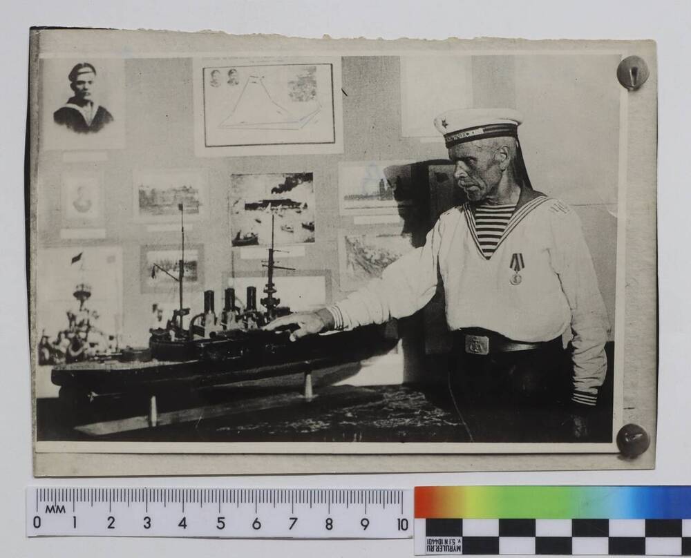 Фотокопия Зиновьев Алексей Степанович, ветеран восстания 1905 года на броненосце Черноморского флота «Князь Потёмкин-Таврический», у макета броненосца.