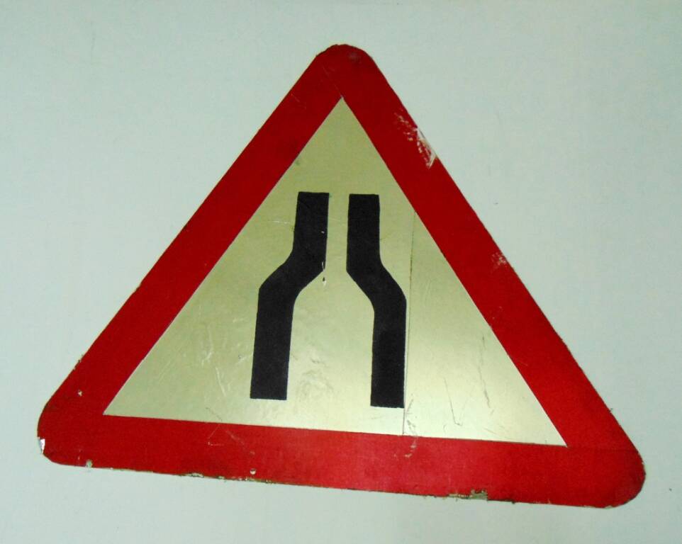 Дорожный знак в виде белого треугольника с красной каймой и изображением черных сужающихся линий - предупреждающий знак Сужение дороги с обеих сторон. 1996 г.