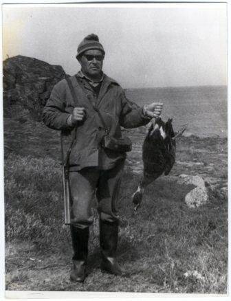 Фотография. Фото сюжетное. Флеров А.И. с убитым гусем на фоне морского побережья.