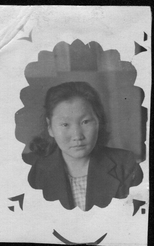 Фотография черно-белая. Портрет погрудный неизвестной девушки в темном пиджаке с короткими завитыми волосами.