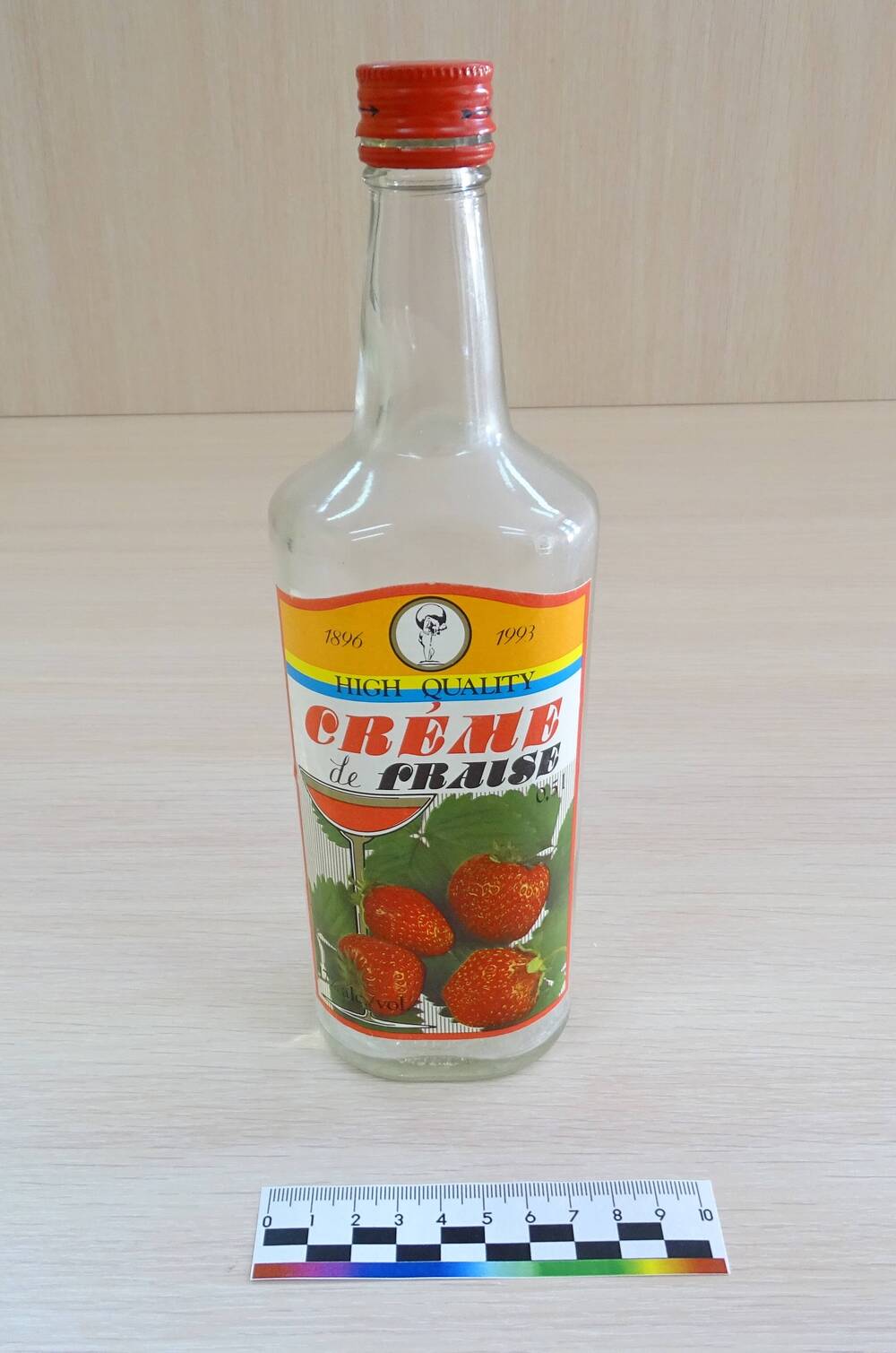 Бутылка «Крем-ликер клубничный» из прозрачного стекла с металлической пробкой красного цвета. Польша, 1993 год.