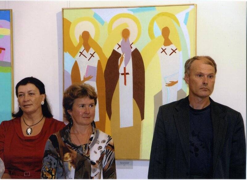 С.Н. Овсянников с художницами О.А. Симоновой и И.Ю. Соловьевой на фоне картин. Фотография