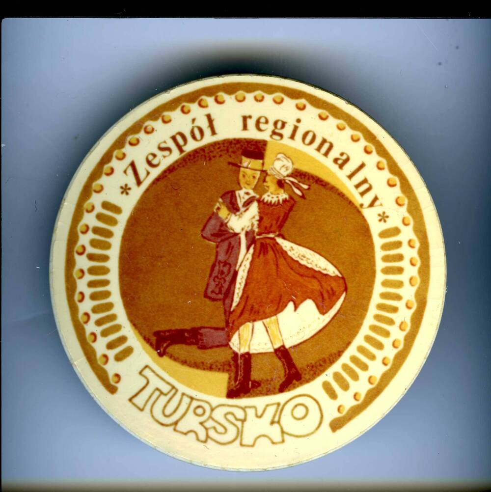 Значок круглой формы с изображением танцующей пары в национальных польских костюмах с надписью: Zеsроt rеgiоnаluy TURSKO.