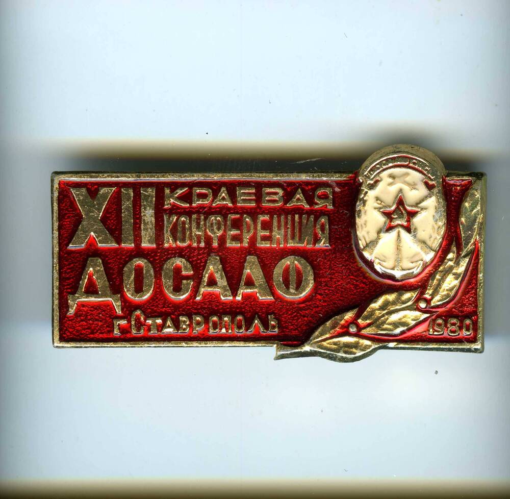 Значок ХII краевая конференция ДОСААФ, г.Ставрополь. 1980 г.. На красной эмали надпись и изображение герба ДОСААФ.