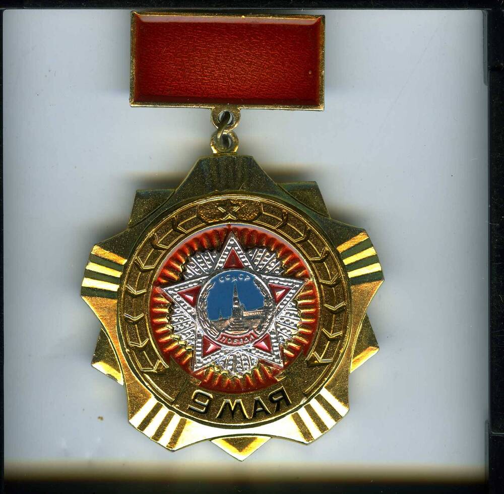 Значок 9 мая с изображением ордена Победы в обрамлении круга со стилизованными колосьями, с колодкой Коновалова Н.Д.