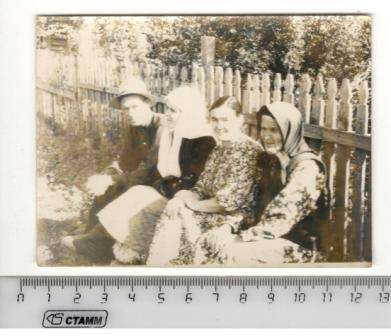 Фото групповое. Юзеев Г. Ф., ветеран Великой Отечественной войны, крайний слева, сидит на скамейке вдоль забора.