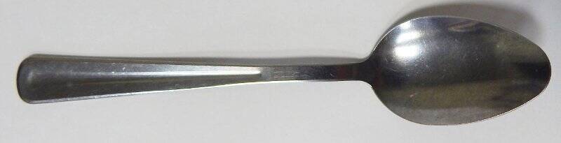 Ложка десертная из металла серого цвета, на ручке вогнутый желобок.