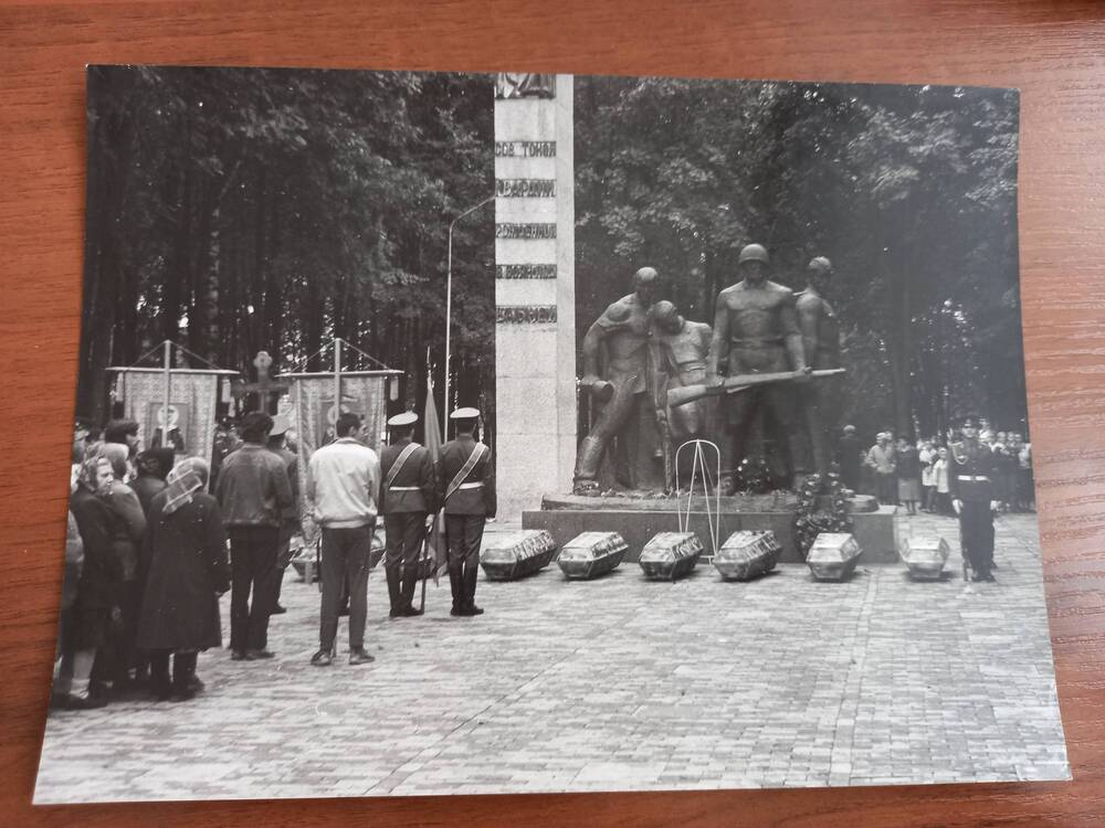 Перезахоронение 96 останков погибших воинов на Ельнинское братское кладбище.На фоне памятника монумента первогвардейцам установлены девять гробов.