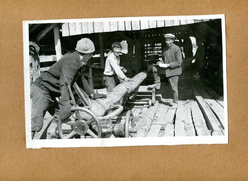 Фото черно-белое. Рабочие совхоза за работой на пилораме.