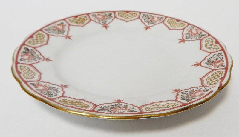 Тарелка пирожковая белого цвета с красно-коричневым орнаментом по ободку.