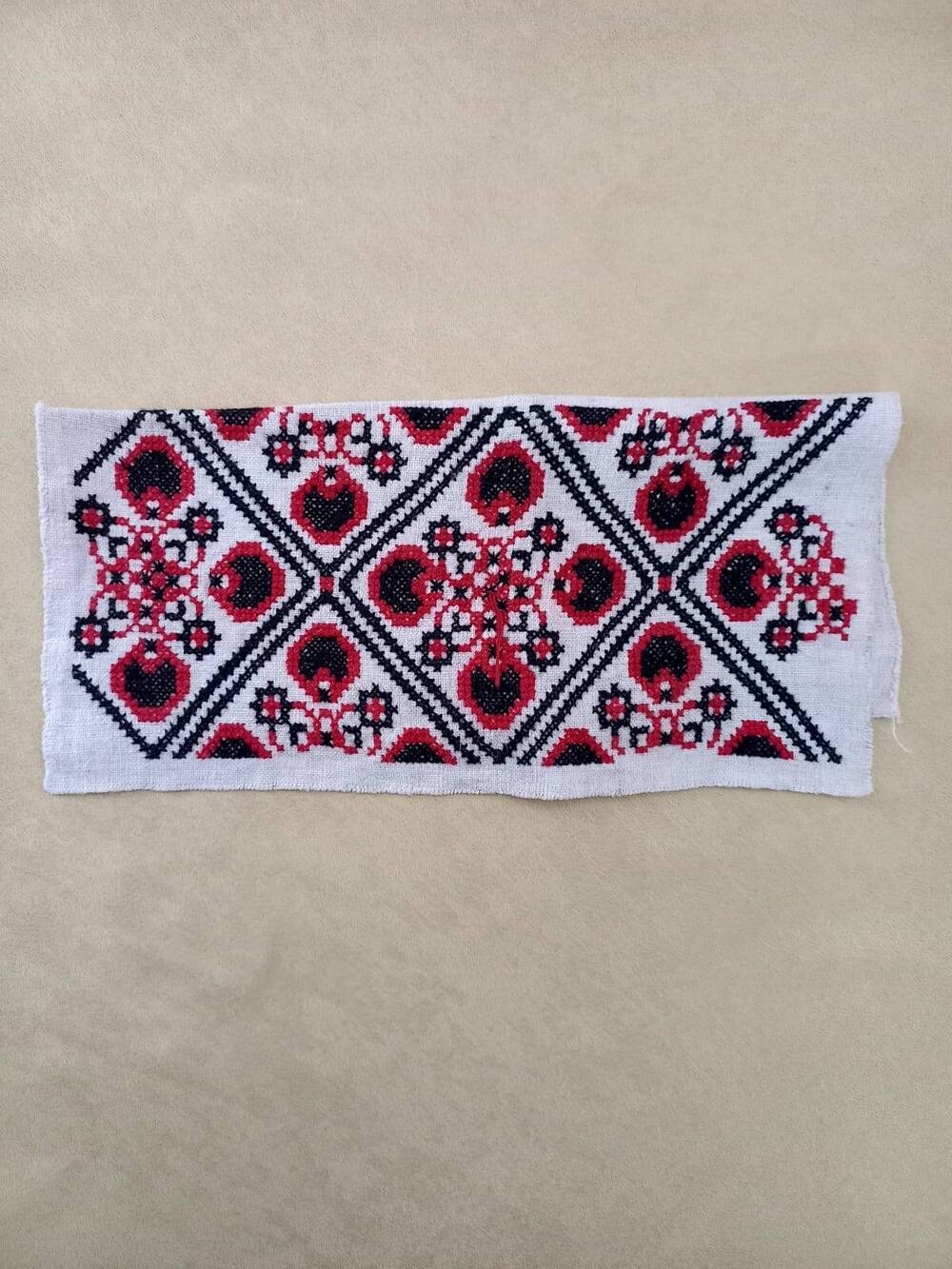Образец вышивки на белом домотканном холсте. Нитки красные и черные. Техника болгарский крест.