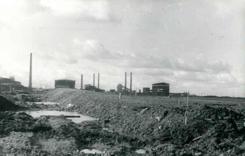 Фотография черно-белая. Вид на завод со стороны города