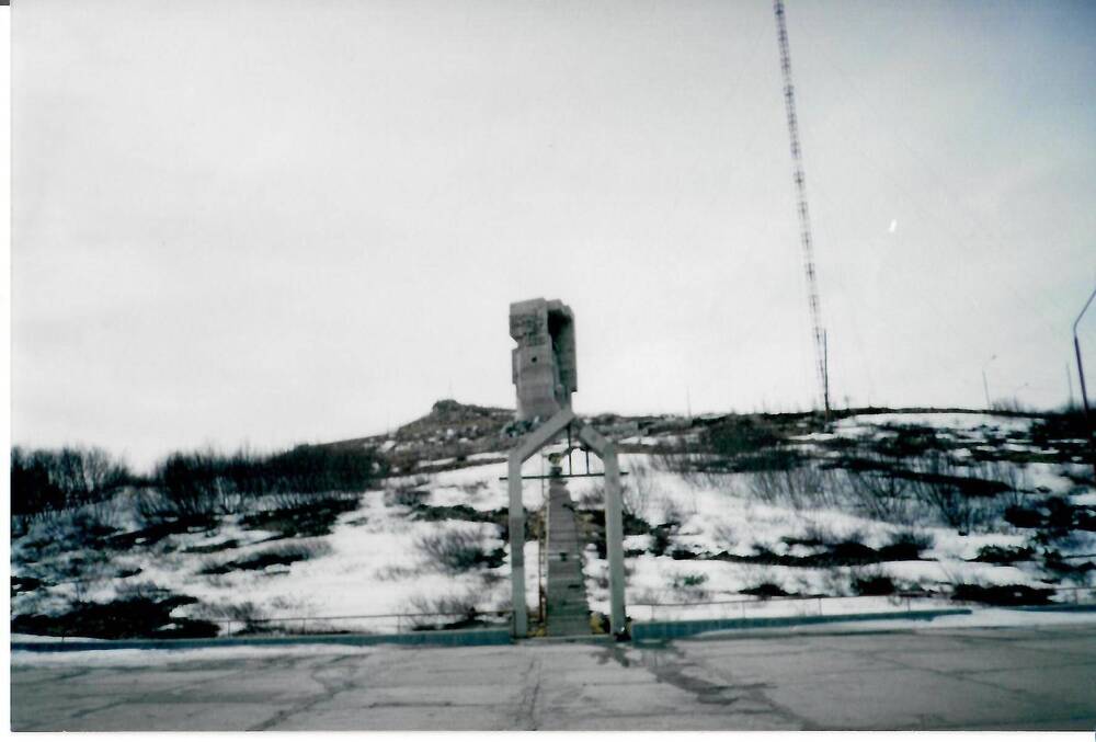 Фотография цветная, матовая печать. Вид на арку и монумент «Маска Скорби» с нижней смотровой площадки, г. Магадан, 1990-е гг.