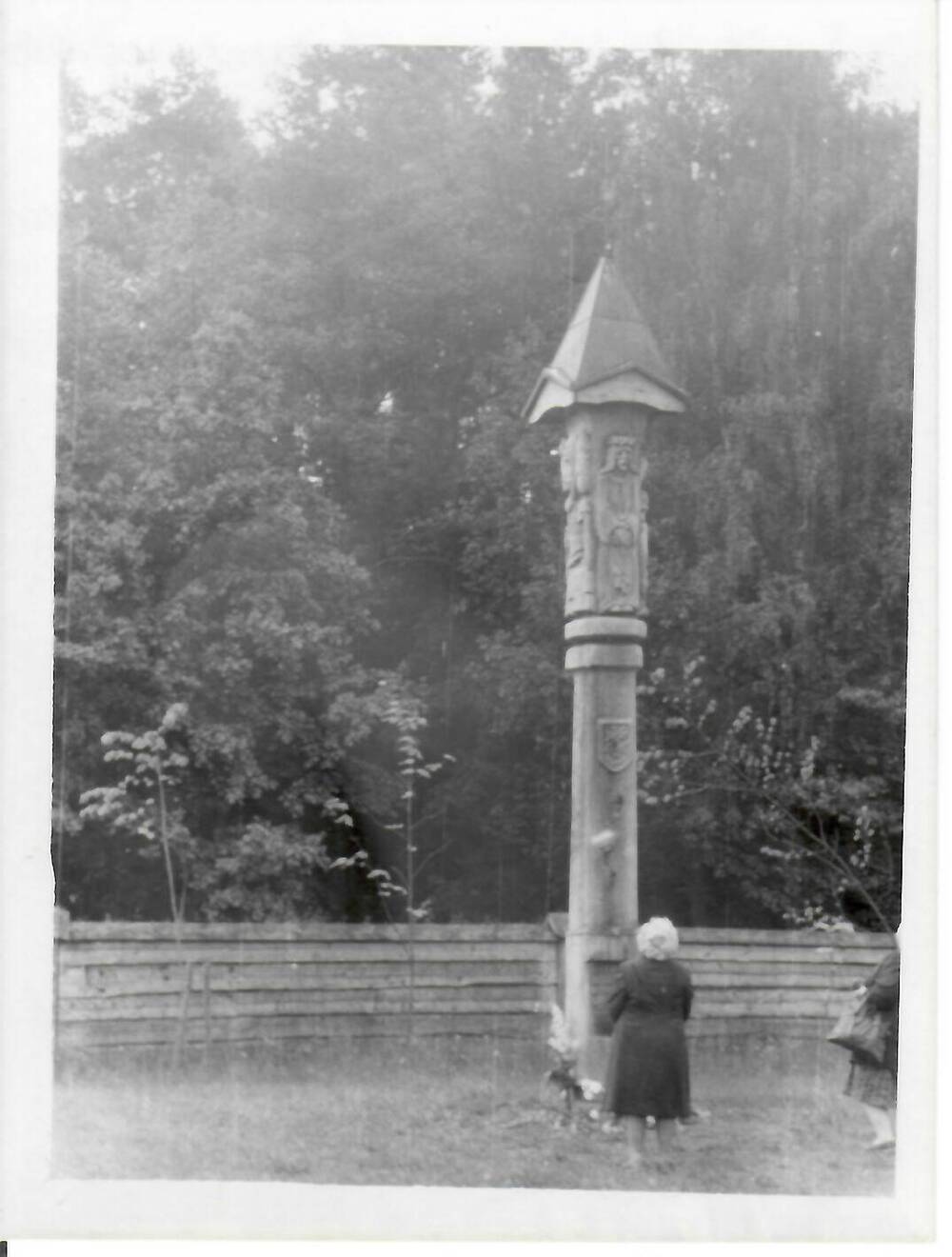 Фотография, черно-белая, глянцевая печать. Женщина стоит перед столпом (традиционный деревянный алтарь Литвы).