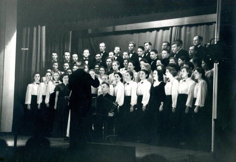 Фотография черно-белая. 14 февраля 1958 года состоялся отчетный концерт русской песни в городском Доме Культуры. На снимке хор под управлением А.А. Разживина