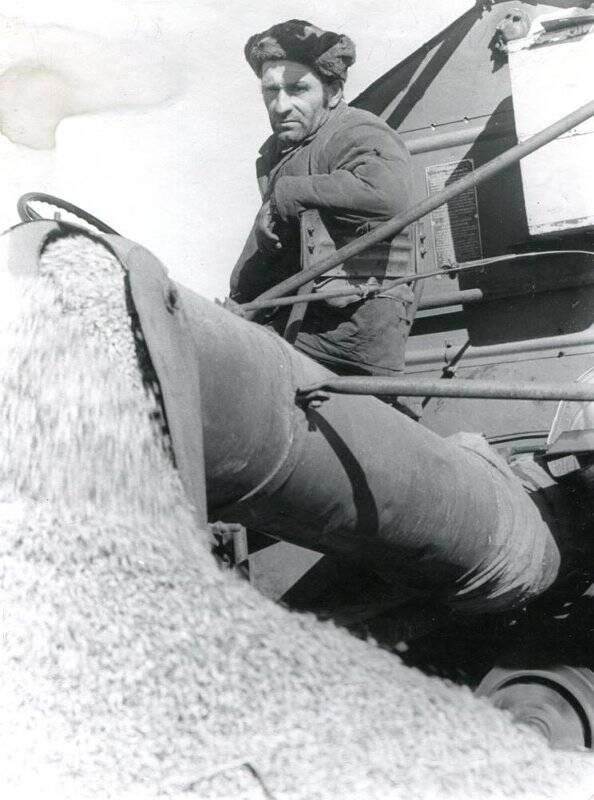 Фотография черно-белая. П.Д. Кужлев, один из передовых механизаторов совхоза Восход, на тереблении льна