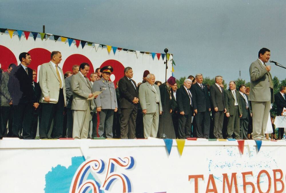 Фото цветное групповое: руководители области и гости г. Тамбова на трибуне   Тамбовского ипподрома на празднике «Урожай – 2002» 7 сентября 2002 г. У микрофона:  губернатор Тамбовской области Бетин О. И.