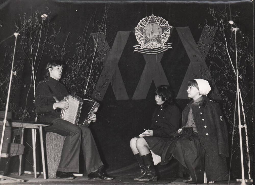 Фото сюжетное: 3 чел. Учащиеся фельдшерского отделения исполняют песни военных лет на вечере, посвященном 30-летию Великой Победы. Снимок 1975 года.