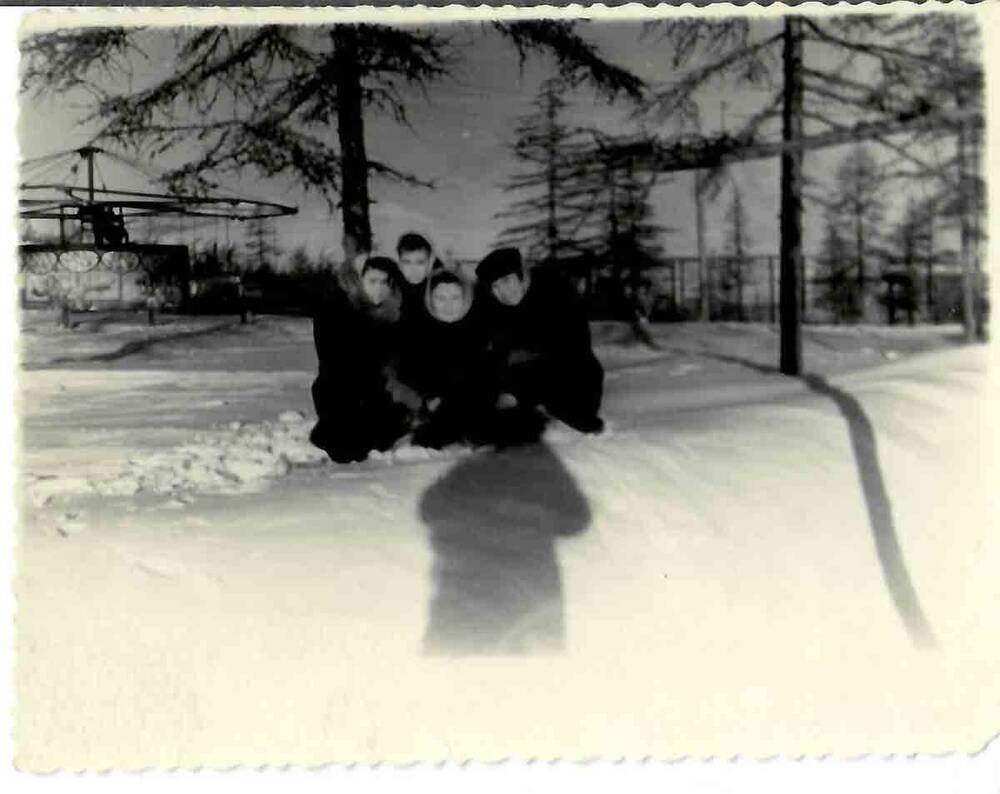 Фотография. В черно-белом цвете. Фигурная обрезка по краям. Группа молодых девушек (4 человека) зимой в городском парке. На оборотной стороне от руки простым грифельным карандашом надпись: «январь 51».